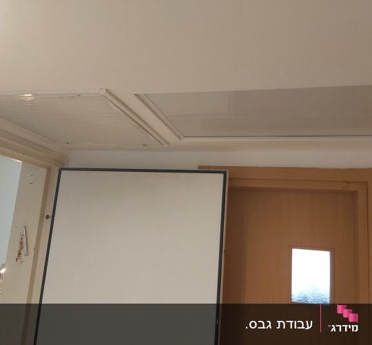 תקרת גבס עם פתחי אוורור ודלת עץ